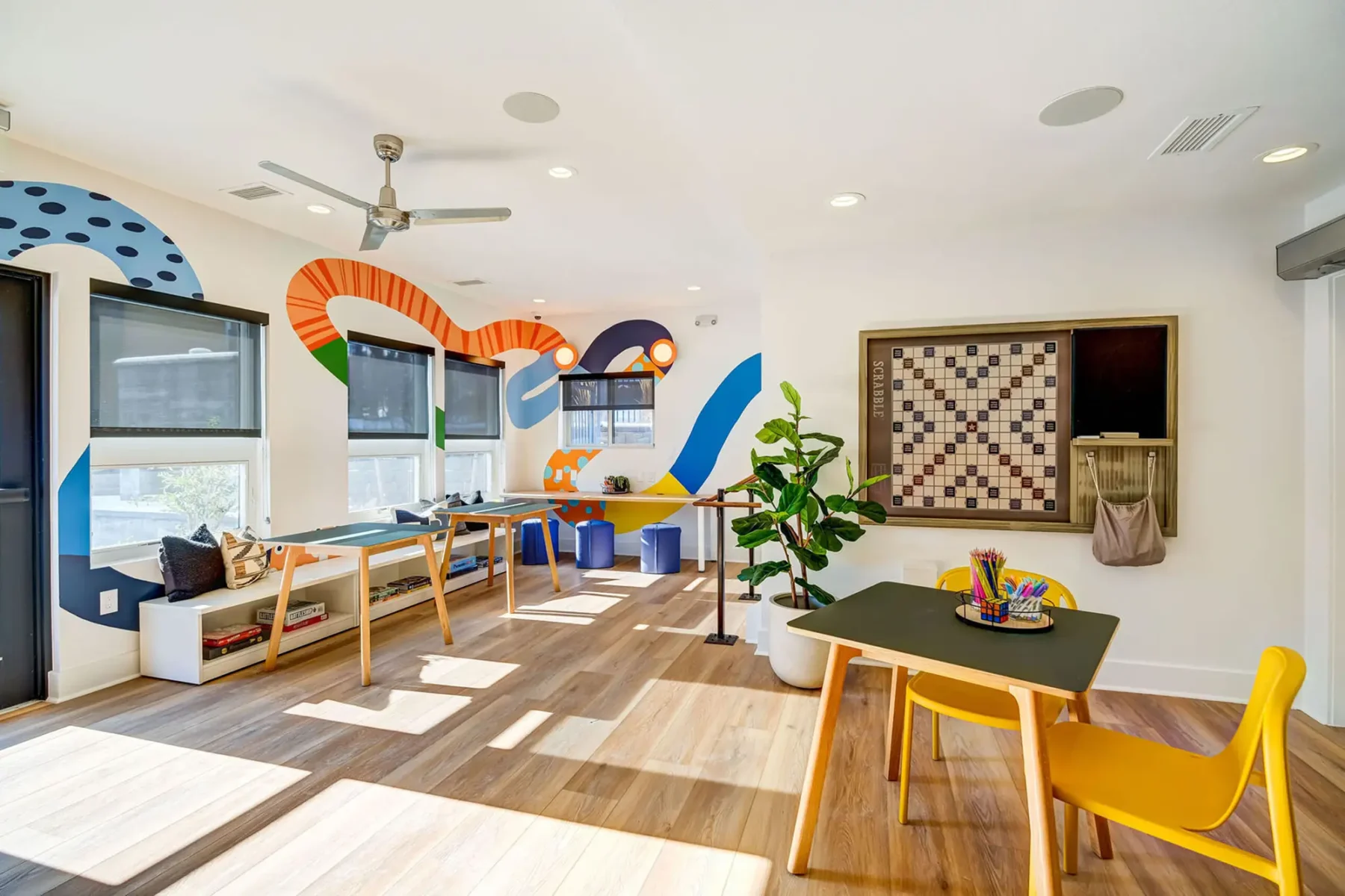 Tuscan Heights Apartments craft and play room for children. Colorful paint, craft tables, seating, and open space.